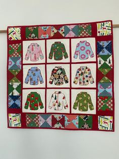 a quilted wall hanging with many sweaters on it