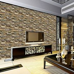 a living room with a large stone wall next to a flat screen tv on top of a wooden table