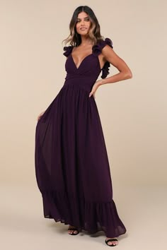 a woman in a long purple dress with ruffles on the sleeves and shoulders