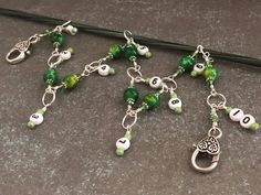 the green and white beaded bracelet has charms on it