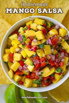 a white bowl filled with mango salsa next to tortilla chips