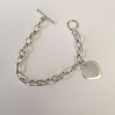 "Oval shaped large link chain in sterling silver with one heart charm.  Heart charm measures 24 mm tall and 0 mm wide.  The links measure 12 mm long by 7 mm wide and are solid.  The bracelet has a toggle clasp. The length of the bracelet is 7 1/2\".  This was preowned.  It is in good condition." Classic Sterling Silver Charm Bracelet With Heart, Sterling Silver Charm Bracelet With Toggle Clasp, Minimalist Silver Chain Bracelet With Heart Charm, Classic Silver Heart Bracelet, Classic Silver Heart Bracelet With Lobster Clasp, Personalized Silver Oval Link Chain Bracelet, Silver Chain Style, Plastic Beads, Circle Pendant