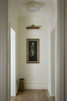 an empty hallway with a painting hanging on the wall