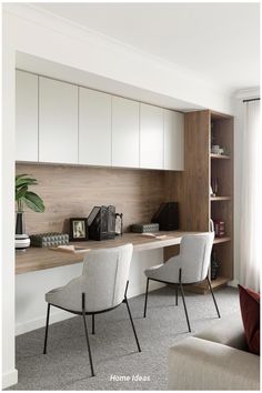 two white chairs sitting in front of a desk