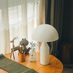 a mushroom shaped lamp sitting on top of a wooden table next to a stuffed animal