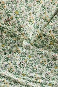 an image of a flowery fabric with green and yellow flowers on the bottom half