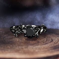 a black diamond ring sitting on top of a wooden table