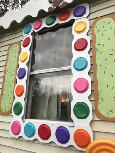 a house decorated with lots of different colored circles and shapes on the side of it