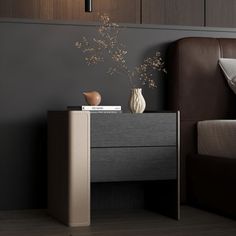 a bedroom with a bed, night stand and vase on the side table in front of it