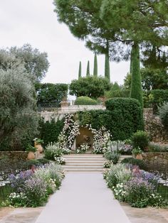 an outdoor wedding ceremony with white flowers and greenery on the steps leading up to it