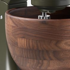 a close up of a wooden bowl with a metal object in the center and an electrical device on top