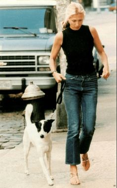 a woman walking her dog on a leash down the sidewalk next to a fire hydrant