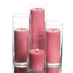 pink candles in glass vases on white background