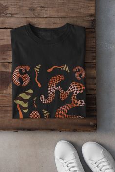 Mushrooms Shirt Printed on a super soft, cotton tee Dispatched in 5 working days or sooner Unisex Free UK delivery Material: 100% ringspun cotton. Chest (to fit): S  34/36   M  38   L  40/42   XL  44/46   XXL  48/50 ECO-FRIENDLY Each garment is made to order, reducing extra material and energy that would be otherwise wasted We use DTG printing process which is easier on the environment than screen-printing Our ink is bright and also eco-friendly. Do not tumble dry. Wash at 30 degrees c, inside o Black Y2k T-shirt With Custom Print, Grunge Graphic T-shirt For Fall, Black Y2k T-shirt For Fall, Black Y2k Style T-shirt For Fall, Fall Goblincore Crew Neck T-shirt, Black Y2k T-shirt For Halloween, Black Y2k Style T-shirt For Halloween, Y2k Black Custom Print T-shirt, Y2k Style Black T-shirt With Custom Print