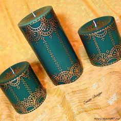 three green candles sitting on top of a table