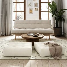 a living room with white furniture and large windows in the back ground, along with potted plants