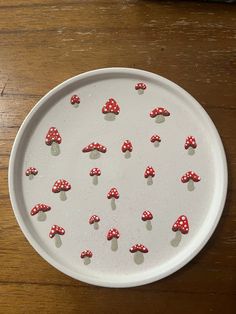 a white plate with red mushrooms on it