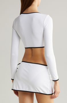 This sporty, long-sleeve rashguard top is made from the brand's lightweight, ribbed fabric and is designed with a cropped hem. Slips on over head Crewneck Long sleeves 92% recycled polyamide, 8% spandex Hand wash, dry flat Imported White Tops With Thumbholes For Loungewear, Cropped Tops With Thumbholes For Loungewear, Spring Activewear With Ribbed Waistband And Long Sleeves, Fitted White Top With Cropped Hem, Fitted White Cropped Top, White Fitted Crop Top With Cropped Hem, White Fitted Top With Cropped Hem, White Fitted Top With Ribbed Cuffs, Ribbed Long Sleeve Sports Activewear