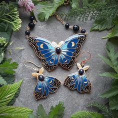 This gorgeous blue and black Celestial Moth jewelry set is hand-sculpted of polymer clay and decorated with Ethiopian opal gems (gems color is enhanced) and covered with glossy resin. The set consists of beautiful Moth necklace and a pair of mythical Moth earrings, but the items are also trade separately. Making these jewelry pieces I was inspired by fairy tales and fantasy stories and of course by the beauty of moths and Nature. So they can be a great gift for a moth lover, nature lover, fantasy lover, Ren Faire goer or just for yourself to add some mysterious atmosphere to your outfit. Despite of being quite large, the earrings are lightweight that makes them comfortable to wear. Pendant width 2 3/4 inches Pendant length 1 3/4 inches Necklace length 20 inches Earring length 2 inches (fro Blue Hand Painted Jewelry As A Gift, Blue Hand Painted Jewelry Gift, Hand Painted Blue Jewelry For Gifts, Blue Hand Painted Jewelry For Gift, Bohemian Resin Jewelry With Matching Earrings, Black Enamel Pendant Jewelry, Collectible Handmade Resin Jewelry, Handmade Mystical Resin Jewelry, Blue Celestial Cabochon Jewelry