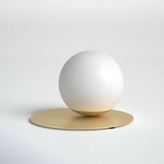 a white ball sitting on top of a gold plate