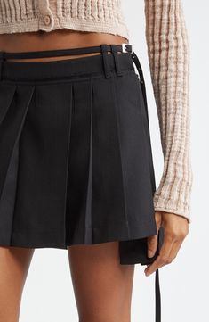 The Stockholm-based label blends the polish of classic suiting with schoolcore charm in this sharply knife-pleated miniskirt lightly kissed with wool. A slender belt designed to lay slightly above the skirt's waistband pays homage to the low-slung silhouettes of Y2K, while an asymmetric hemline furthers the statement-making aesthetic. Removable belt Unlined 55% polyester, 45% wool Dry clean Made in Portugal Designer Clothing Fall Mini Skort With Belt Loops, Chic Pleated Mini Hem Skort, Elegant Formal Mini Pleated Skirt, Workwear Short Pleated Skirt With Belt Loops, Workwear Pleated Skirt With Belt Loops, Short Length, Accordion Pleated Skort For Workwear, Accordion Pleated Skort For Work, Accordion Pleats Skort For Workwear, Fitted Mini Skirt With Belt Loops For Fall