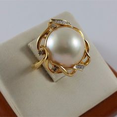 Beautiful 18K Karat 750 Yellow Gold Mabe Pearl & Diamond Ring  Condition : Pre-Owned Professionally Polished to look New Total Weight : 8.7 Grams Gold Color : Yellow Gold Pearl Size : 14.20mm Total of 10 Round Cut Diamonds  (Please See Pictures for more detail on the Sizes; they are by Millimeter) What you see in the pictures is what you will receive. Pearl Diamond Ring, Pearl And Diamond Ring, Mabe Pearl, Fancy Earrings, Rose Gold Band, Pearl Diamond, Pearl Size, Gold Pearl, Pearl Ring