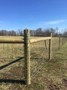 a wooden fence in the middle of a field