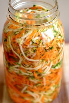 a glass jar filled with shredded carrots and other vegetables