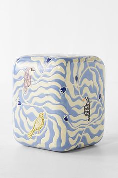 a blue and white ceramic container with sea animals on it's sides, sitting on a table