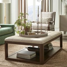 a living room with a couch, chair and coffee table in front of a window