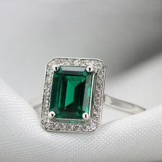 Handmade by an inspired jewelry artist team with decades of experience in the craft of jewelry making.Each gemstone, each diamond is carefully picked.Using only the finest raw materials and the highest industry standard in manufacturing, design and finish.A Stunning Emerald and diamonds ring, handmade to order in any size.Flaunting a prong set 8 x 6 mm, octagon cut Green chatham emerald.The stone is set a little high on the finger maximizing its presence and appeal. Ring features:............... Timeless Green Rings With Accent Stones, Classic Emerald Cut May Birthstone Rings, Elegant Emerald Cut Gemstone Halo Ring, Emerald Cut Diamond Birthstone Ring With Halo Setting, Heirloom Green Birthstone Ring For May, Heirloom Green May Birthstone Ring, Timeless Cubic Zirconia Emerald Ring For Anniversary, Classic Diamond Ring With Accent Stones For May Birthstone, Formal Emerald Birthstone Ring With Center Stone