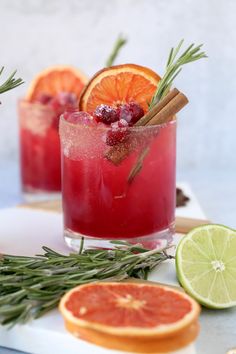 two glasses filled with blood oranges and rosemary garnish