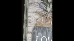 the word joy is painted on an old door with flowers in a vase next to it