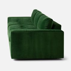 a green couch sitting on top of a white floor