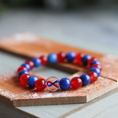 Handcrafted with genuine jade gemstones and a custom hand painted glass ribbon bead. Natural gemstones used so color and pattern will vary.   Red & Blue ribbon awareness: Congenital Heart Defect Awareness, CHD Bracelets: Please enter your bracelet size.  Common sizes are 6, 6.5, 7, 7.5, or 8 inches.  Custom sizes available.  Custom requests welcome Patriotic Colorful Beads Bracelet For Gift, Patriotic Beaded Bracelets With Colorful Beads As Gift, Patriotic Red Beaded Bracelets As Gift, Adjustable Patriotic Stretch Bracelet Gift, Patriotic Beaded Bracelets For Gifts, Adjustable Glass Beaded Bracelets As Gift, Round Glass Beaded Bracelets As Gift, Round Glass Beaded Bracelets For Gift, Patriotic Round Beads Jewelry Gift