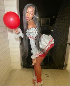 a woman with long gray hair holding a red balloon