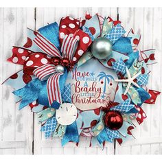 a wreath with red, white and blue ribbons on it that says have yourself a beachy christmas