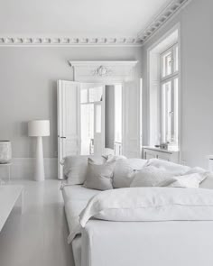 a large white bed sitting in the middle of a room