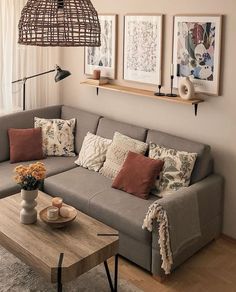 a living room with a couch, coffee table and pictures on the wall above it