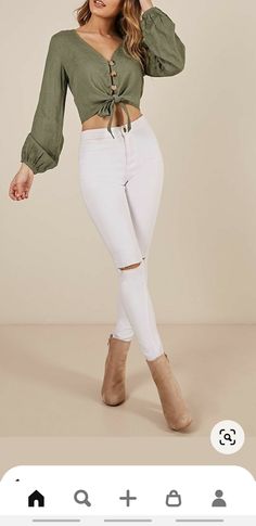 a woman in white jeans and a green top is posing for the camera with her hands on her hips