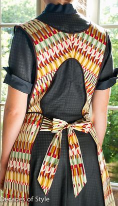 the back of a woman's dress with an abstract pattern on it and a bow at the waist