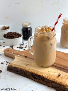 two mugs filled with hot chocolate on top of a cutting board