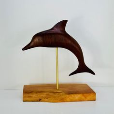 a wooden sculpture of a dolphin on a stand