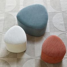 three different colored stools sitting on top of a floor next to eachother