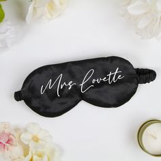 a black eye mask with mr and mrs lovette written on it next to some flowers