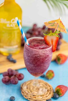 a smoothie is garnished with strawberries and blueberries