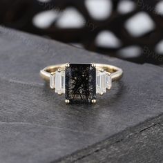 a black and white diamond ring sitting on top of a wooden table