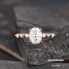 a close up view of a diamond ring on top of a stone slab with other items in the background