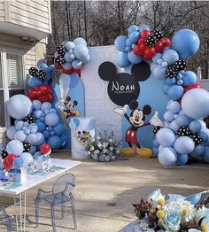 a mickey mouse balloon arch is decorated with balloons