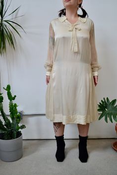 "1920s Handmade? Cream Silk Shift Dress. Drop Waist. Sheer Sleeves. Classic Collar. Bow Detail in Front. Smocked Sleeve Cuffs. Smocked Side Panels. No Content Label- Feels Like Silk No Size Tag Fits S/M Fair Vintage Condition - Small Rips Throughout, Tiny Stains Near Collar, Hole on Sleeve. Pit Stains *Not all damage is photographed. If you would like more photos or info let us know! Please familiarize yourself with our policies page.* Chest - 40\" Waist -38\" Hips-39\" Sleeve Length-24\" Should 1920s Style Spring Daywear Dresses, 1920s Style Spring Day Dresses, 1920s Style Day Dresses For Spring, Smocked Sleeve, Dress Drop Waist, Historical Costuming, Pit Stains, Cute Jumpers, Silk Shift Dress